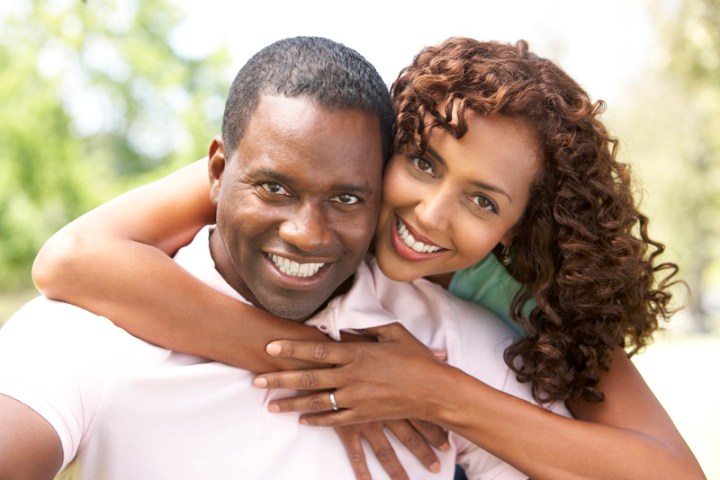 Portrait Of Young Couple Sitting In Park